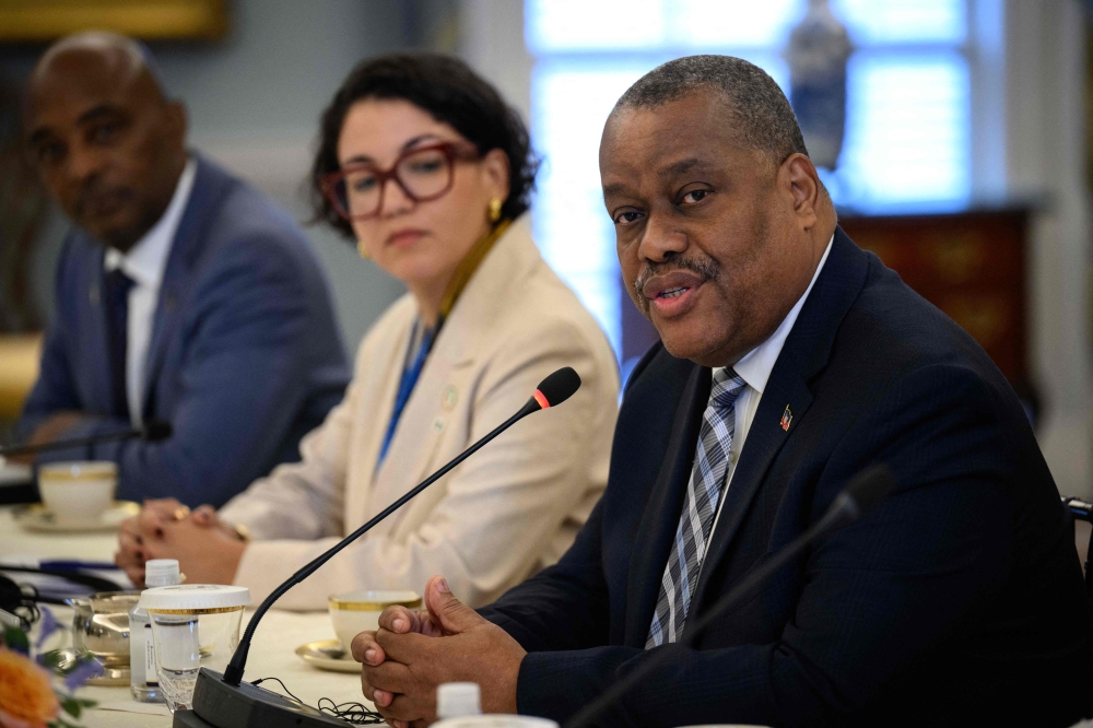 Haitian Prime Minister Garry Conille (R) speaks as Haitian Foreign Minister Dominique Dupuy (C) looks on during a meeting with US Secretary of State Antony Blinken at the State Department in Washington, DC, on July 2, 2024. (Photo by Drew ANGERER / AFP)
