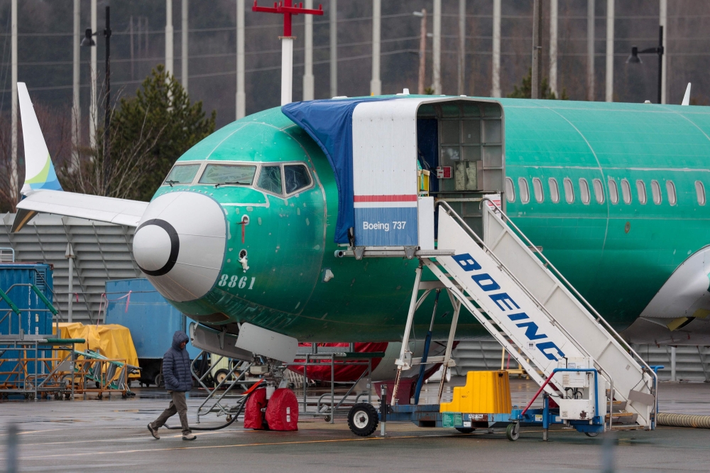 File: A person walks past an unpainted Boeing 737-8 MAX parked at Renton Municipal Airport adjacent to Boeing's factory in Renton, Washington on January 25, 2024.  (Photo by Jason Redmond / AFP)
