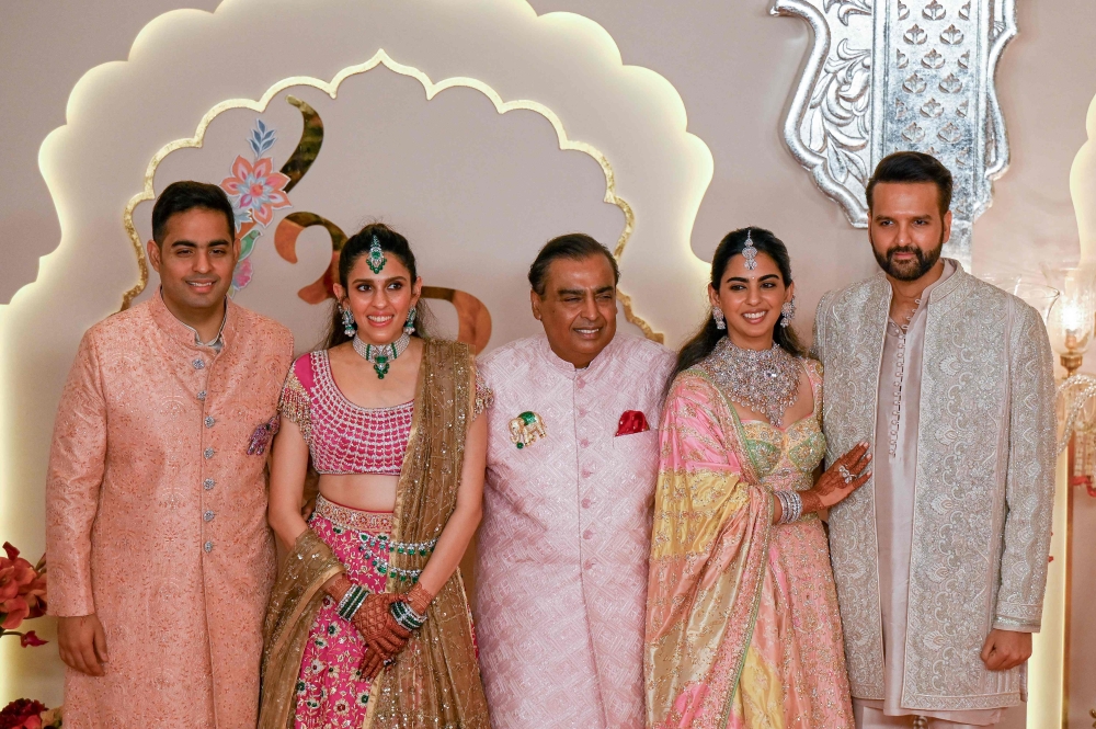 Billionaire tycoon and Chairman of Reliance Industries Mukesh Ambani (centre), daughter Isha Ambani (2R), son Akash Ambani (L), daughter-in-law Shloka Mehta (2L), and son-in-law Anand Piramal pose for photos as they arrive to attend the wedding ceremony of Anant Ambani and Radhika Merchant in Mumbai on July 12, 2024. (Photo by Punit Paranjpe / AFP)