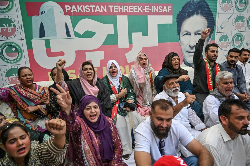 Supporters of former prime minister Imran Khan and his Pakistan Tehreek-e-Insaaf (PTI) party celebrate after a Supreme Court verdict, in Karachi on July 12, 2024. (Photo by Asif HASSAN / AFP)
