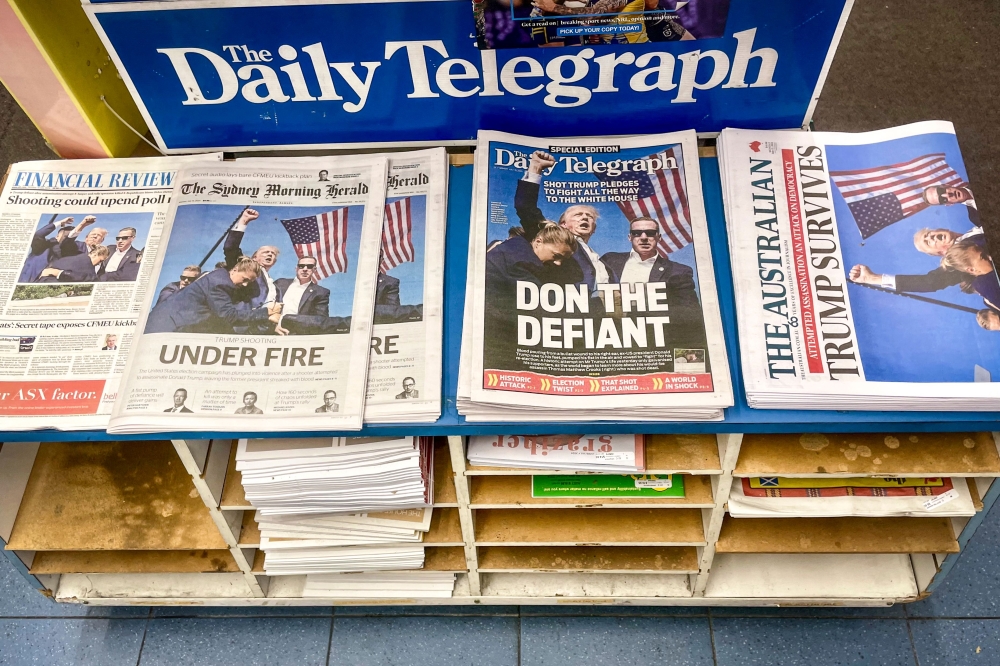 The morning newspapers on display at a shop in Sydney on July 15, 2024, show the headlines and photos after the assassination attempt. (Photo by David Gray / AFP)