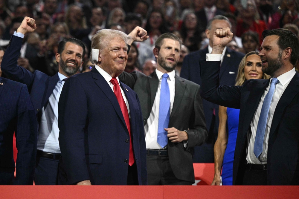 US former President and 2024 Republican presidential candidate Donald Trump (bottom L) smiles as he is cheered on during the first day of the 2024 Republican National Convention at the Fiserv Forum in Milwaukee, Wisconsin, July 15, 2024. (Photo by Brendan Smialowski / AFP)