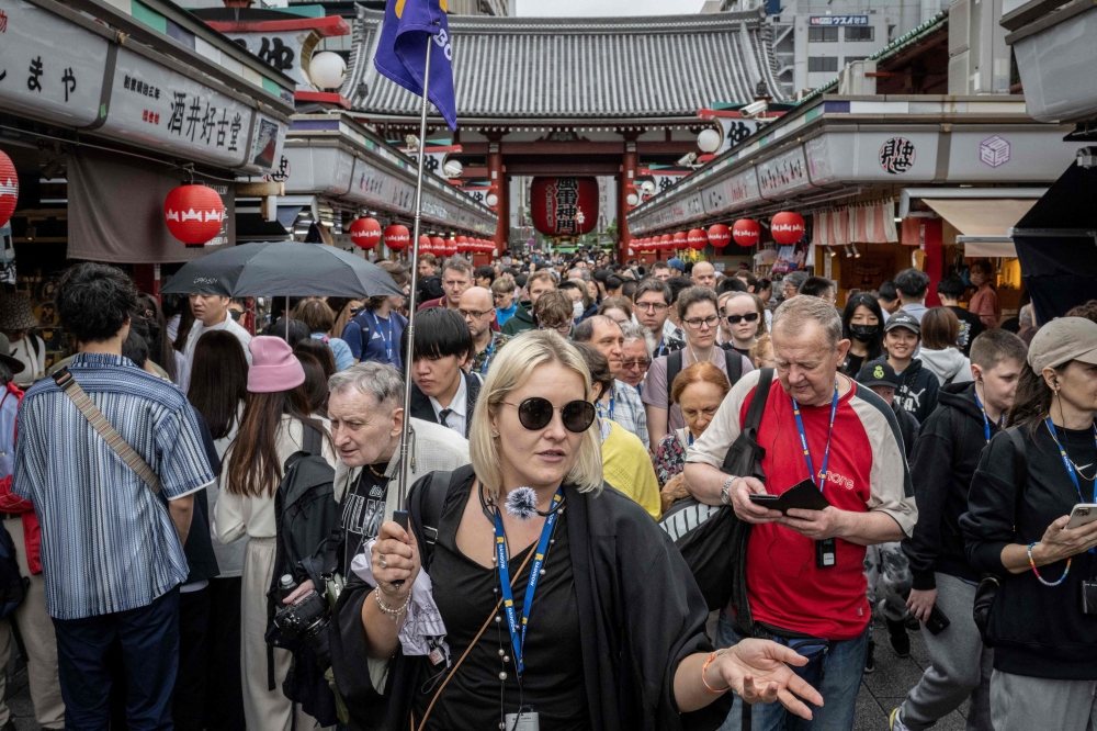 This file photo taken on April 30, 2024 shows tourists walking through Nakamise shopping street near Sensoji Temple in Tokyo. Photo by Yuichi YAMAZAKI / AFP