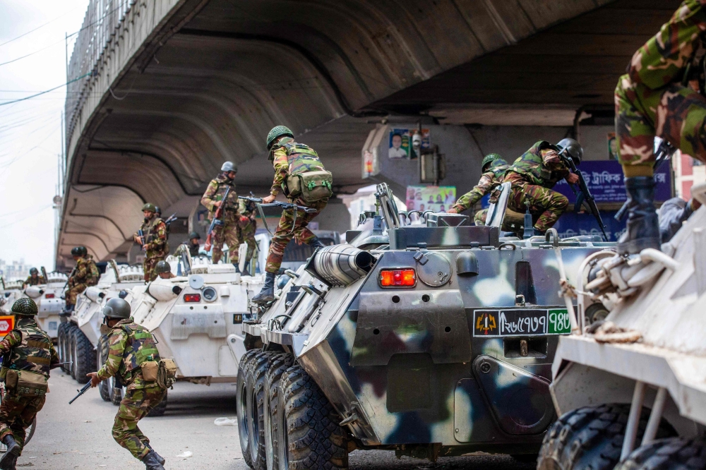 Bangladeshi soldiers disembark armored vehicles as they patrol the streets to disperse the anti-quota protesters in Dhaka on July 20, 2024. (Photo by AFP)