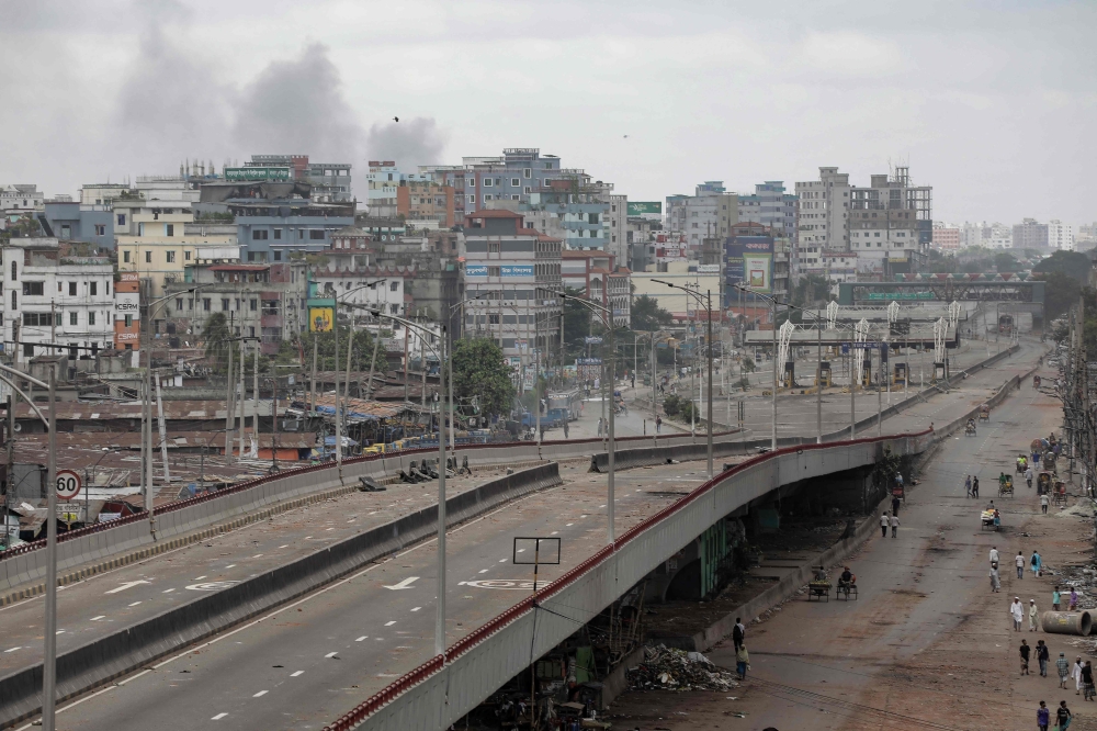 Smoke bellows from the backside of Dhaka's southern outskirt neighbourhood as clash erupts between police and anti-quota protesters in Dhaka, Bangladesh, July 21, 2024. (Photo by Anik Rahman / AFP)
