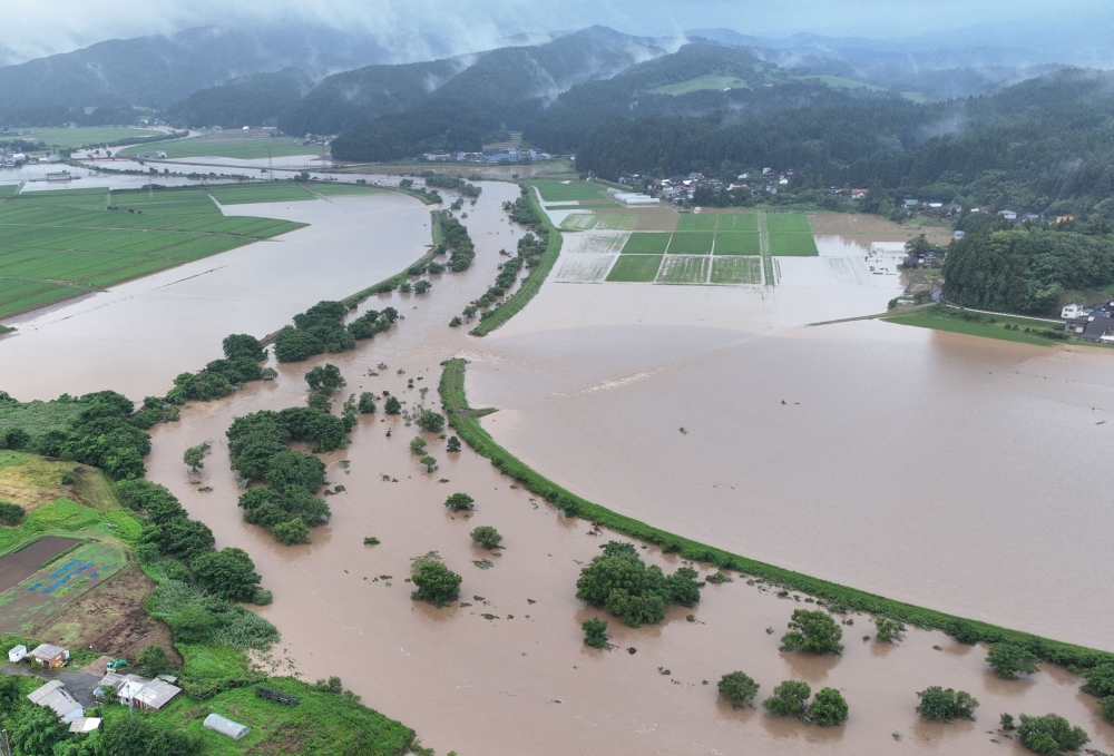 This handout photo taken on July 25, 2024 and released courtesy of the Akita Prefecture River Sabo Division to AFP on July 26, shows flooding along the Ishizawa river, whose embankment collapsed due to heavy rains, in Yurihonjo, Akita prefecture. Photo by Handout / Akita Prefecture River Sabo Division / AFP