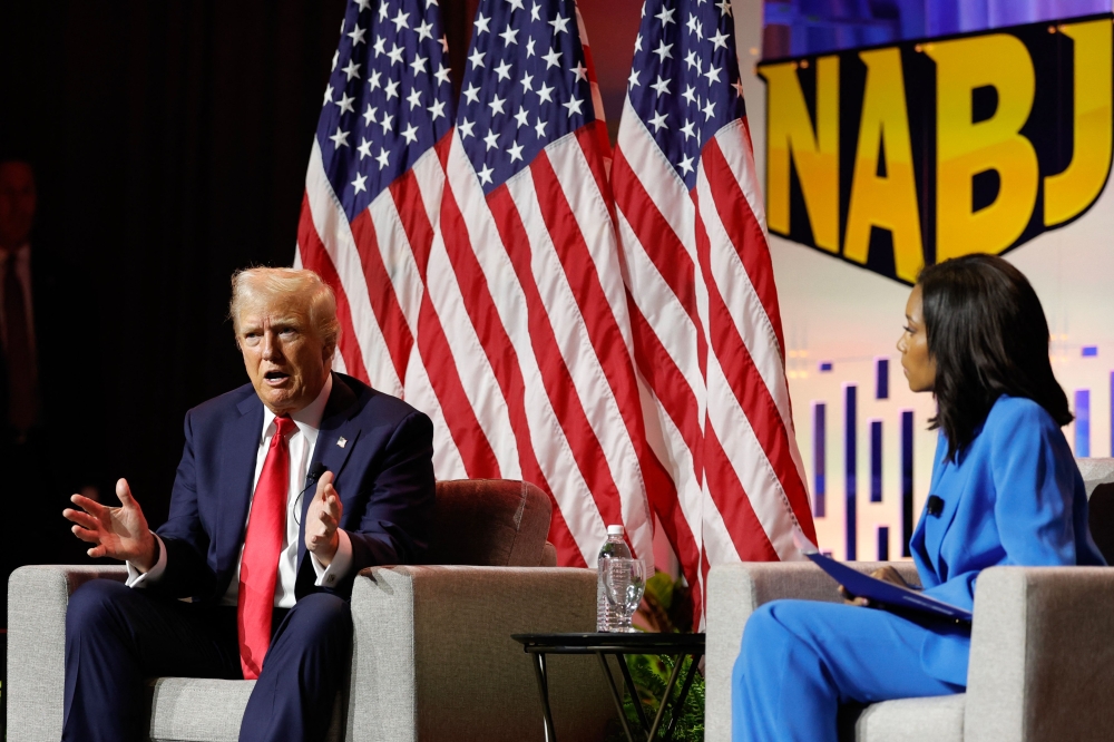Former US President and 2024 Republican presidential nominee Donald Trump answers questions as moderator and journalist Rachel Scott looks on during the National Association of Black Journalists annual convention in Chicago, Illinois, on July 31, 2024. (Photo by Kamil Krzaczynski / AFP)