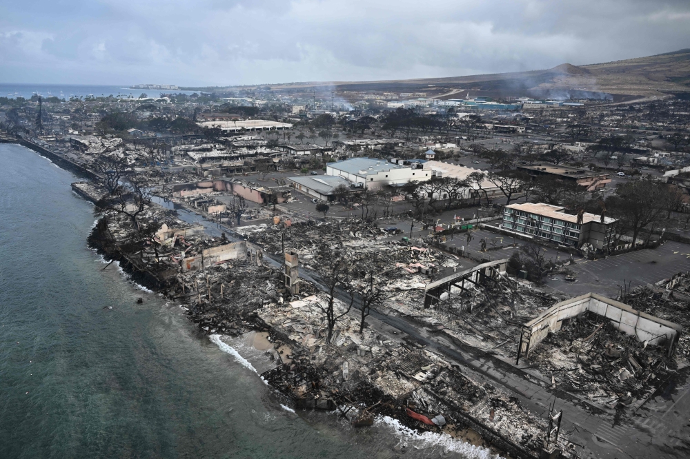 An aerial image shows Old Lahaina Center and Foodland Lahaina standing amongst destroyed homes and businesses along Front Street burned to the ground in the historic Lahaina in the aftermath of wildfires in western Maui in Lahaina, Hawaii on August 10, 2023. Photo by Patrick T. Fallon / AFP