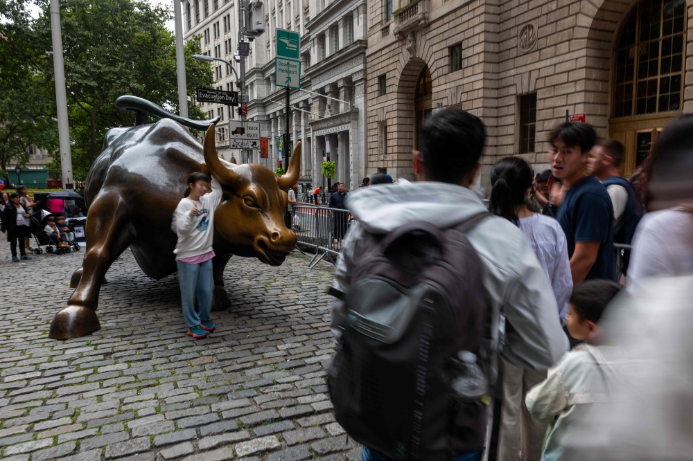 People take pictures at the Wall Street Bull on August 08, 2024 in New York City. (Photo by SPENCER PLATT / GETTY IMAGES NORTH AMERICA / Getty Images via AFP)
