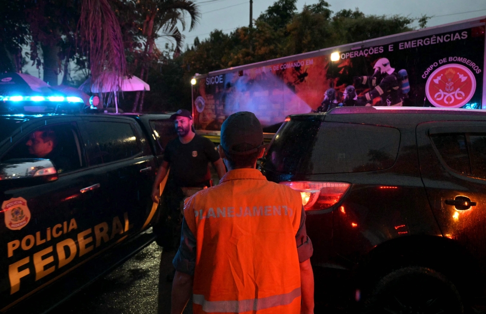 Emergency personnel arrive at the entrance of Recanto Florido Condominium, where an airplane crashed in Vinhedo, Sao Paulo State, Brazil, on August 9, 2024. (Photo by Nelson Almeida / AFP)