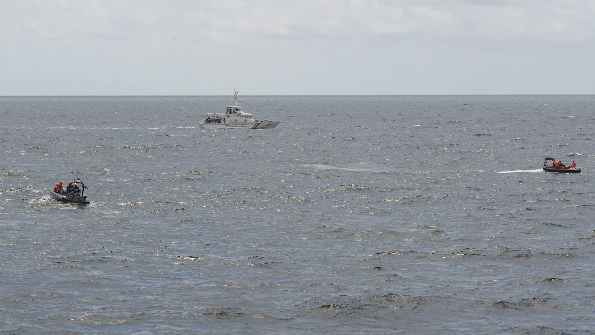 Philippine Coast Guard personnel (L) maneuover their rigid hull inflatable boat past their Vietnamese counterparts (R) during a joint maritime off Bataan in the disputed South China Sea on August 9, 2024. (Photo by Ted ALJIBE / AFP)

