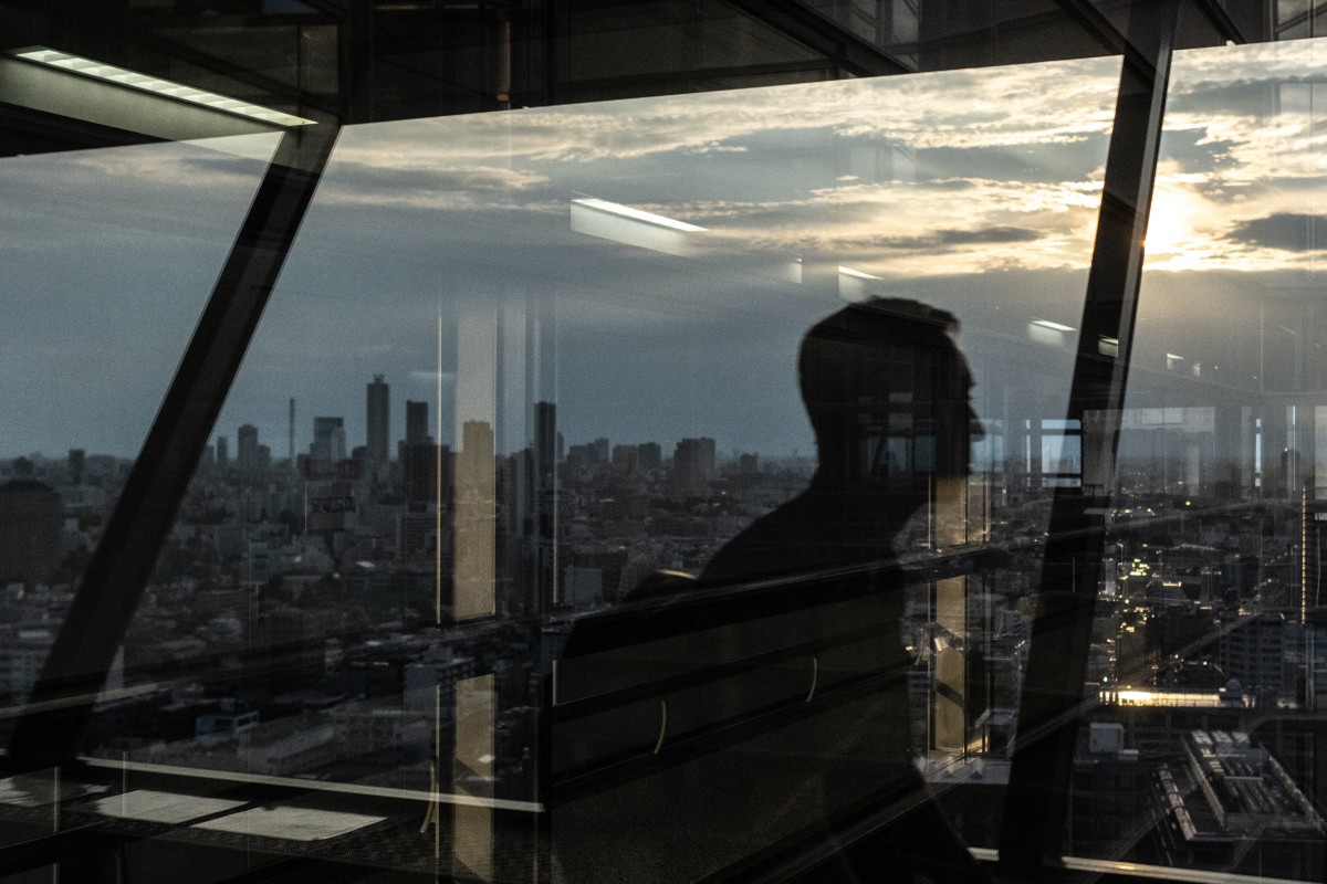 A man walks at the Bunkyo Civic Center Observation Deck as the city's skyline is seen in Tokyo on August 14, 2024. (Photo by Philip FONG / AFP)
