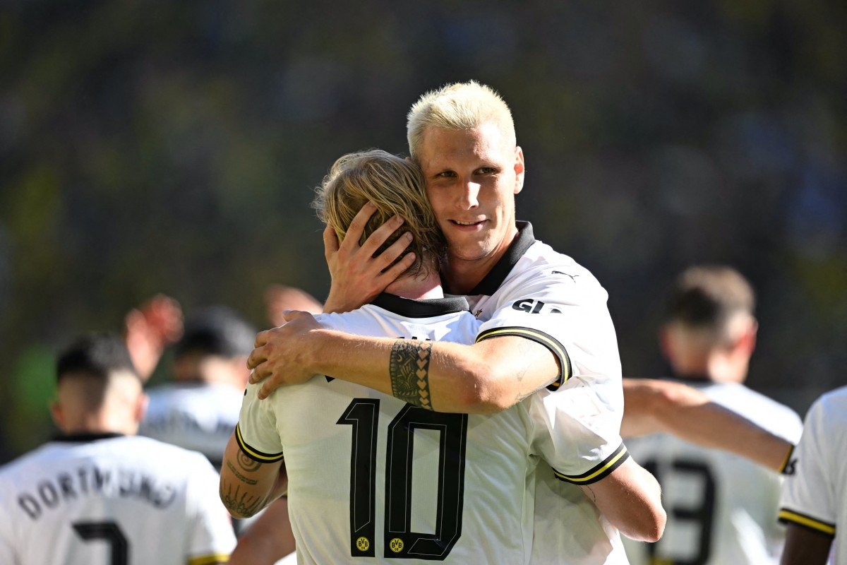 Dortmund's German midfielder #10 Julian Brandt (L) is celebrated by Dortmund's German defender #25 Niklas Suele after scoring the 2-0 goal during the pre-season friendly club football match between Germany's BVB Borussia Dortmund and England's Aston Villa FC in Dortmund, western Germany on August 10, 2024. Photo by INA FASSBENDER / AFP.