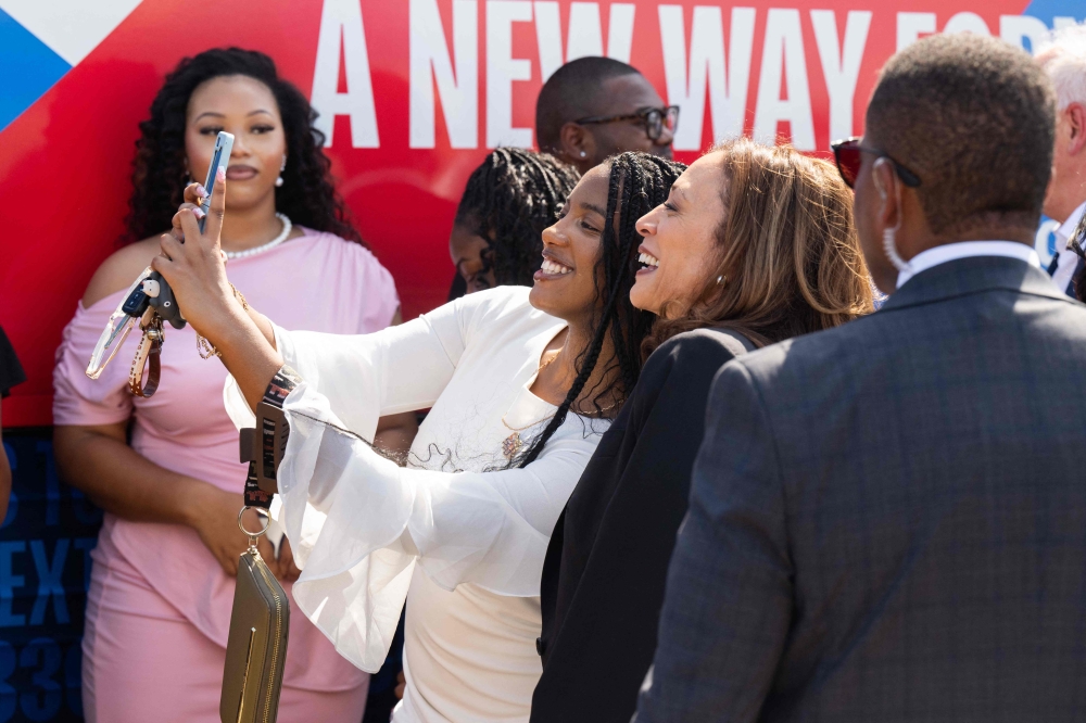 US Vice President and Democratic presidential candidate Kamala Harris takes photos with supporters upon arrival at Savannah/Hilton Head International Airport in Savannah, Georgia, August 28, 2024, as she travels for a 2-day campaign bus tour. (Photo by Saul Loeb / AFP)
