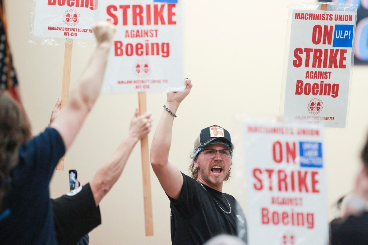 Union members react as Aerospace Machinists District 751 President Jon Holden (out of frame) announces that union members rejected a proposed Boeing contract and will go on strike, following voting results at their union hall in Seattle, Washington, on September 12, 2024. Photo by Jason Redmond / AFP