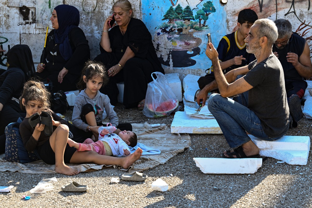 People who fled Israeli bombardment on Beirut's southern suburbs, gather in the Lebanese capital's downtown district where they spent the night, on September 28, 2024. Photo by JOSEPH EID / AFP.