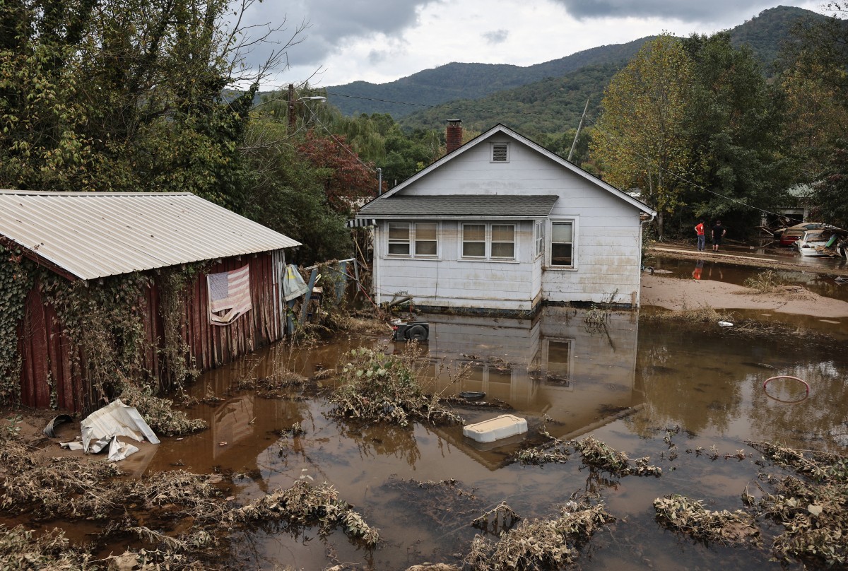 An American flag hangs above floodwaters remaining from Hurricane Helene on October 4, 2024 in Swannanoa, North Carolina. Photo by MARIO TAMA / GETTY IMAGES NORTH AMERICA / Getty Images via AFP.