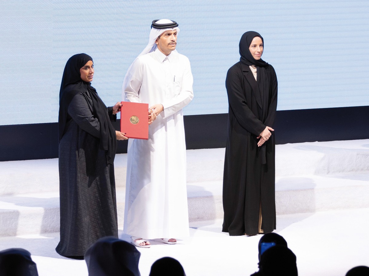 Prime Minister and Minister of Foreign Affairs H E Sheikh Mohammed bin Abdulrahman bin Jassim Al Thani honouring a teacher as Minister of Education and Higher Education H E Buthaina bint Ali Al Jabr Al Nuaimi looks on.