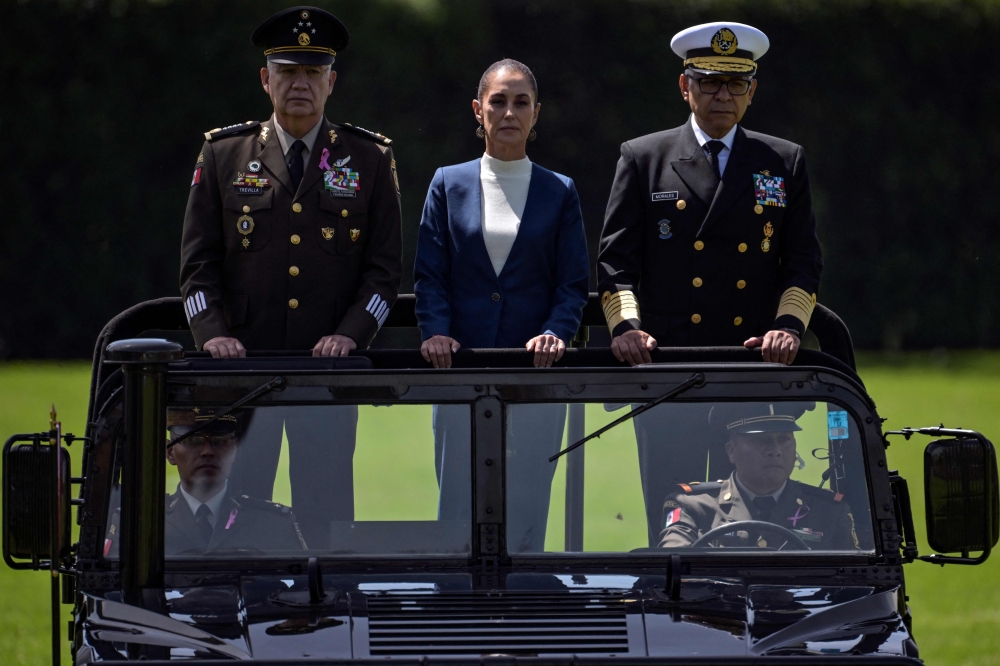 File photo for representational purposes only. Mexico's President Claudia Sheinbaum (C), flanked by Defense Minister Ricardo Trevilla (L) and Secretary of the Navy Raymundo Pedro Morales (R), reviews troops during her inauguration ceremony as the new Supreme Commander of the Mexican Armed Forces at Campo Marte in Mexico City on October 3, 2024. (Photo by Yuri CORTEZ / AFP)

