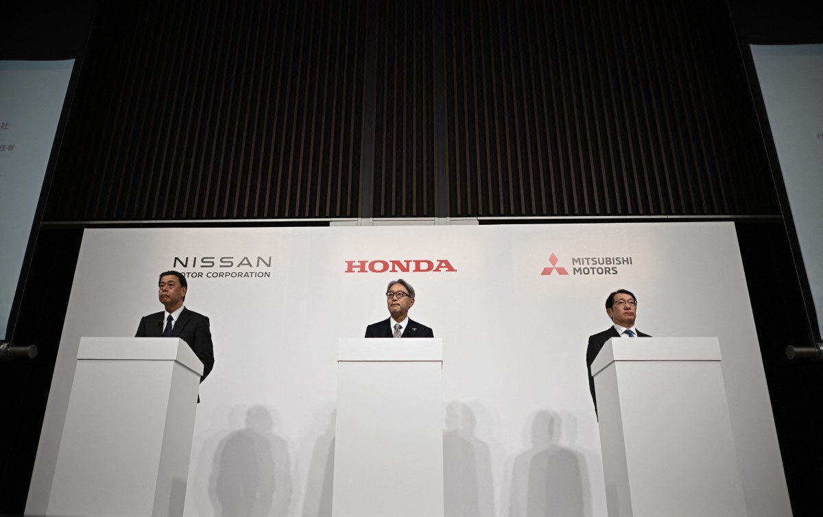 (L to R) Makoto Uchida, President and CEO of Nissan motor corporation, Toshihiro Mibe, President and Representative Executive Officer of Honda, and Takao Kato, President and CEO of Mitsubishi Motors attend a joint press conference in Tokyo on December 23, 2024. Photo by Philip FONG / AFP.
