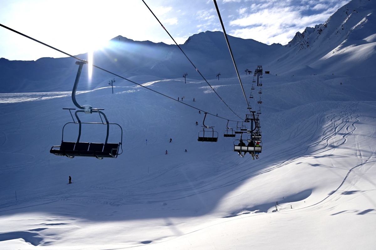 (FILES) Skiers sit on chairlifts at Sainte-Anne, a small ski resort near La Condamine-Chatelard, in the French Alps, on January 6, 2024. (Photo by Nicolas TUCAT / AFP)
