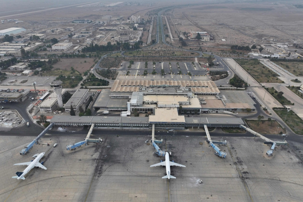 An aerial view shows passenger planes of Syria's private airline company Cham Wings on the tarmac of the closed international airport of Damascus on December 11, 2024. (Photo by Omar Haj Kadour / AFP)