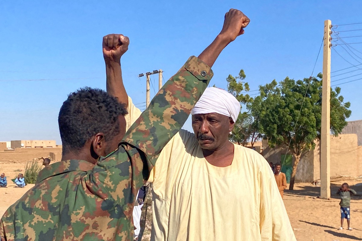 Sudanese people lift their fists as they celebrate on a street in Meroe in the country's Northern State on January 11, 2025, after the army announced entering key Al-Jazira state capital Wad Madani, held by the paramilitary Rapid Support Forces (RSF). (Photo by AFP)
