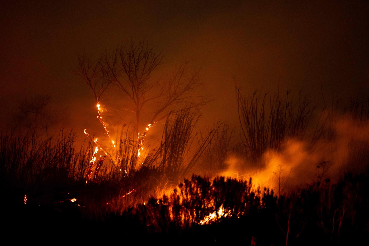 The Auto Fire spreads following the riverbed of the Santa Clara River in Oxnard, North West of Los Angeles, California, on January 13, 2025. (Photo by ETIENNE LAURENT / AFP)
