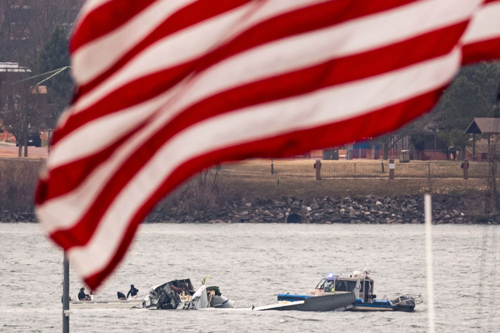 Recovery teams search the wreckage after the crash of an American Airlines plane on the Potomac River as it approached the airport on January 30, 2025 in Arlington, Virginia. (Photo by Al Drago/Getty Images/AFP)
