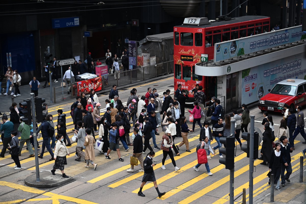 People cross an intersection in the Central business district of Hong Kong on February 27, 2024 on February 28. (Photo by Peter PARKS / AFP)