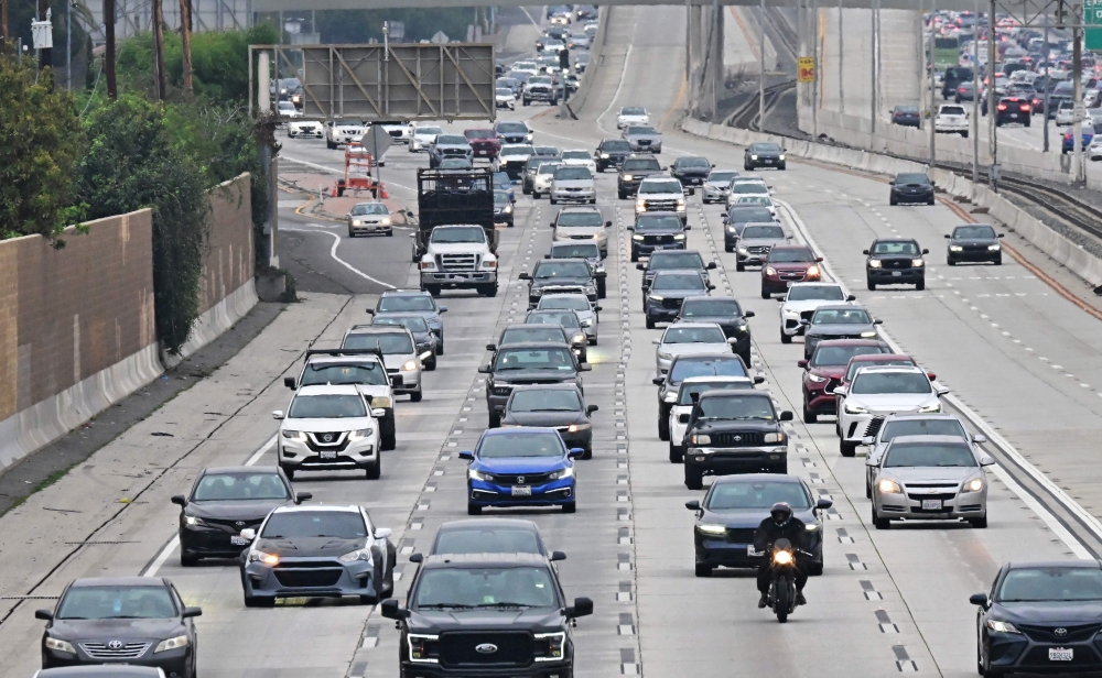 A motorcyclist is seen among drivers during the Los Angeles evening rush hour commute on March 26, 2025 in Alhambra, California. (Photo by Frederic J. BROWN / AFP)