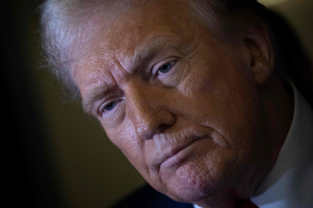 US President Donald Trump listens to a question while speaking to members of the press while returning to Washington, DC on Air Force One on March 30, 2025, in Fredericksburg, Virginia. (Photo by Brendan Smialowski / AFP)