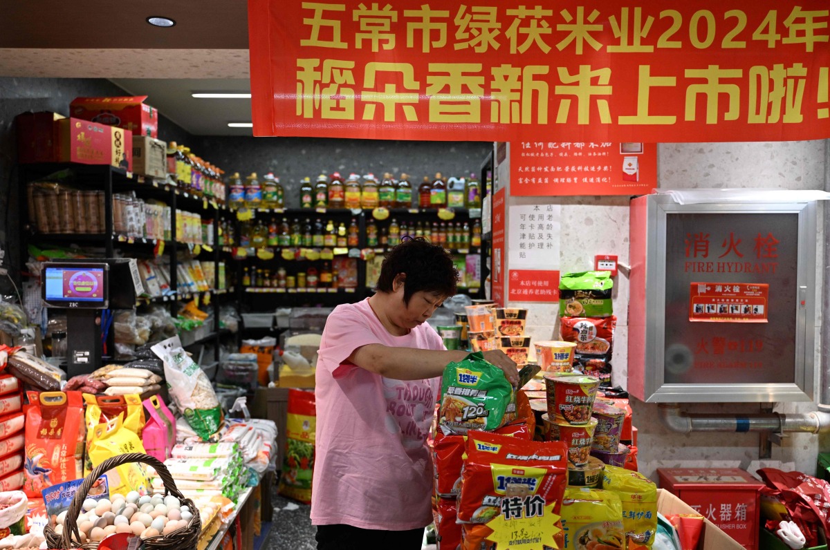 A vendor works at a market in Beijing on April 16, 2025. (Photo by Adek BERRY / AFP)
