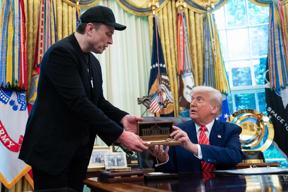 US President Donald Trump gives to Elon Musk a 