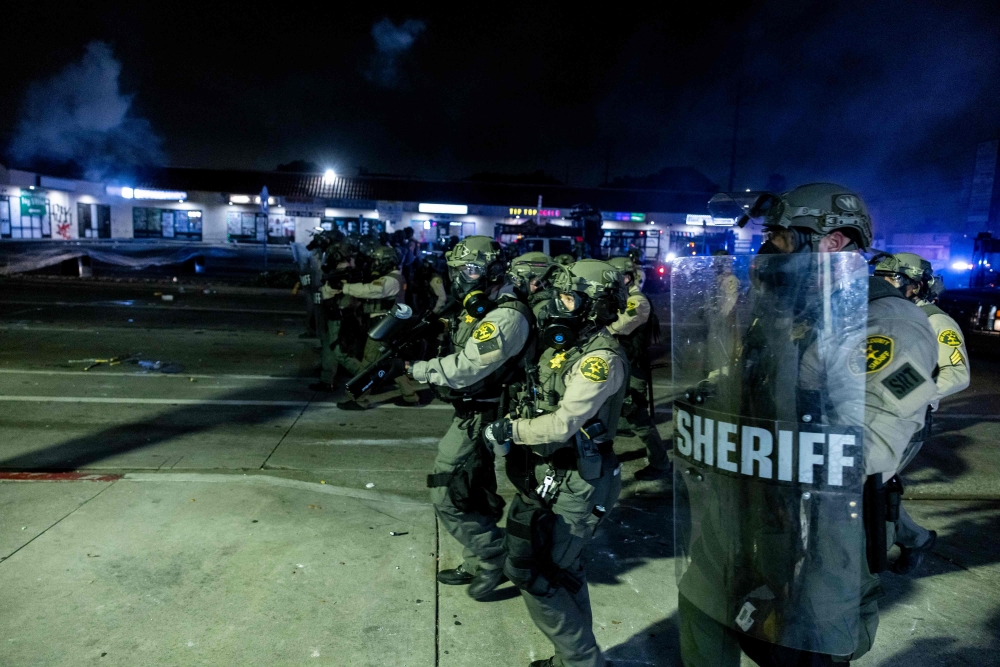 Law enforcement clash with demonstrators during a protest following federal immigration operations, in the Compton neighborhood of Los Angeles, California early on June 8, 2025. (Photo by Etienne Laurent / AFP)