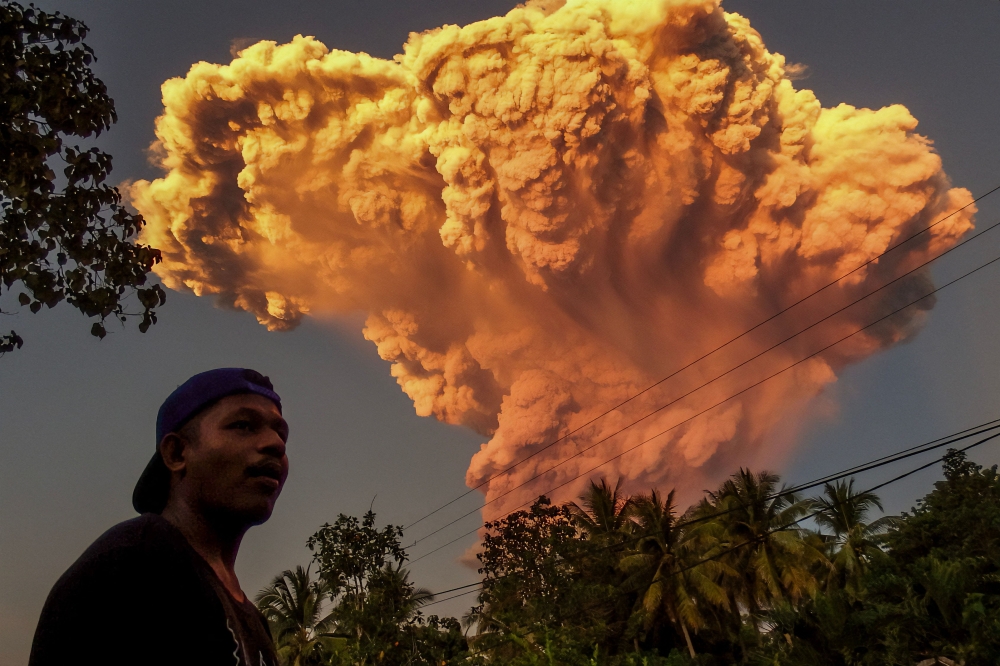 A villager watches the eruption of Mount Lewotobi Laki-Laki as seen from Talibura village in Sikka, East Nusa Tenggara, on June 17, 2025. (Photo by AFP)
 