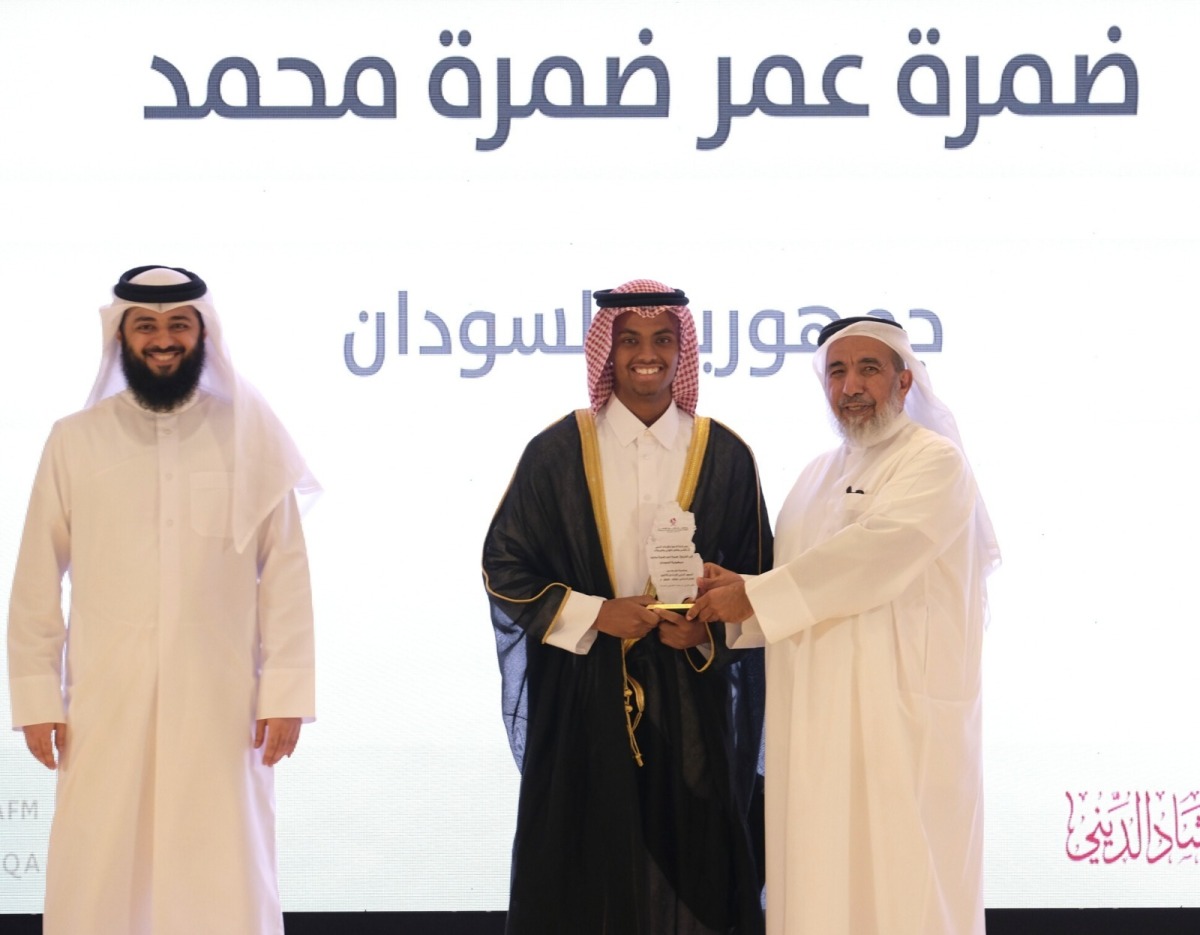 Minister of Awqaf and Islamic Affairs H E Ghanem bin Shaheen bin Ghanem Al Ghanim honouring a student at the graduation ceremony.