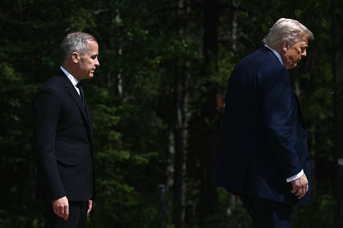 (FILES) Canadian Prime Minister Mark Carney (L) greets US President Donald Trump during an arrival ceremony at the Group of Seven (G7) Summit at the Pomeroy Kananaskis Mountain Lodge in Kananaskis, Alberta, Canada on June 16, 2025. (Photo by Brendan SMIALOWSKI / AFP)
