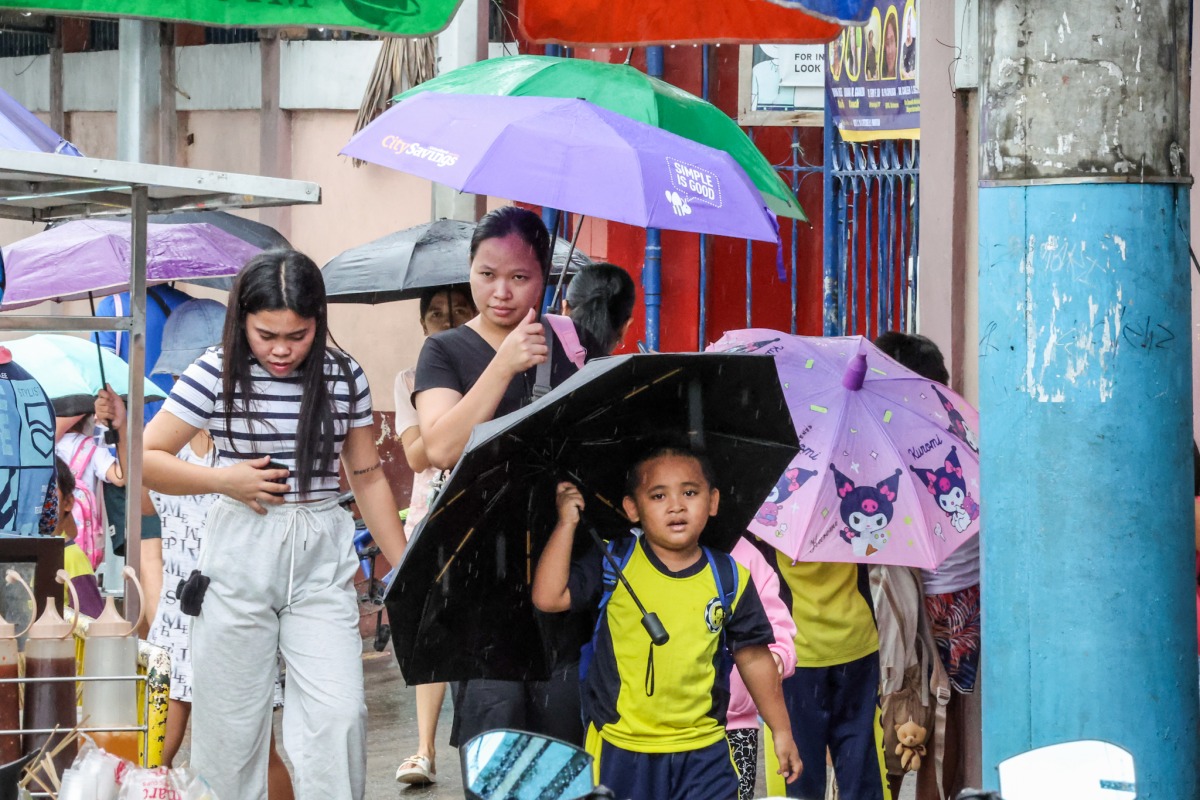  A student holds an umbrella outside a school after classes were suspended due to the tropical storm Wipha in Quezon City, the Philippines, on July 18, 2025. (Xinhua/Rouelle Umali)