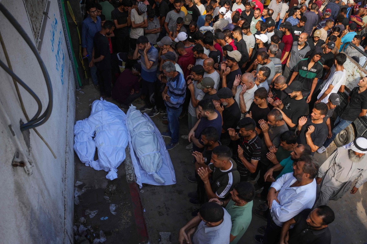 Palestinians pray by the bodies of people killed a day earlier while waiting for aid, during a funeral service at the Al-Shifa hospital in Gaza City on July 31, 2025. Photo by BASHAR TALEB / AFP