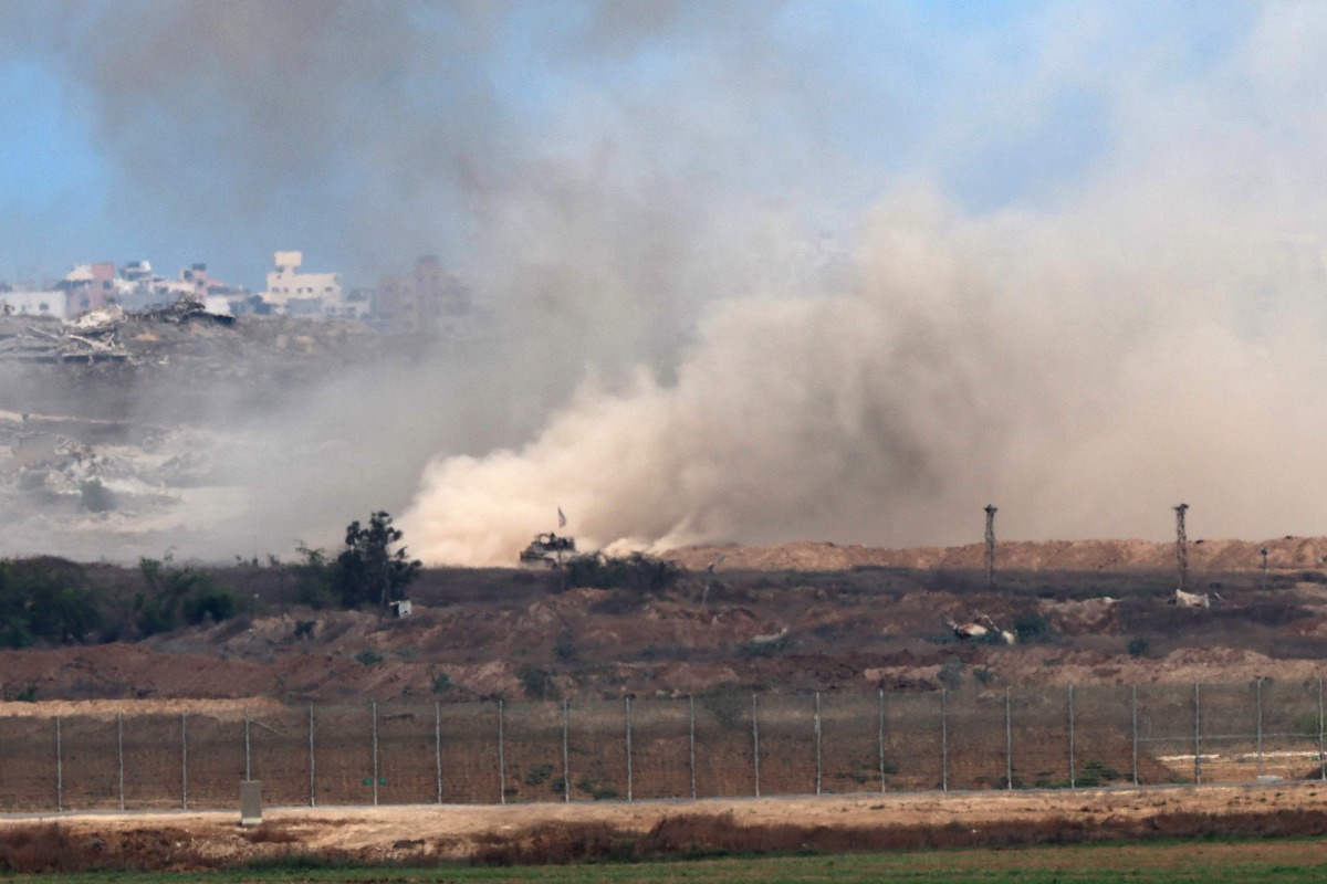 A picture taken from a position at the Israeli border with the Gaza Strip, shows an Israeli Tank moving in the besieged Palestinian territory on August 1, 2025. (Photo by Jack GUEZ / AFP)
