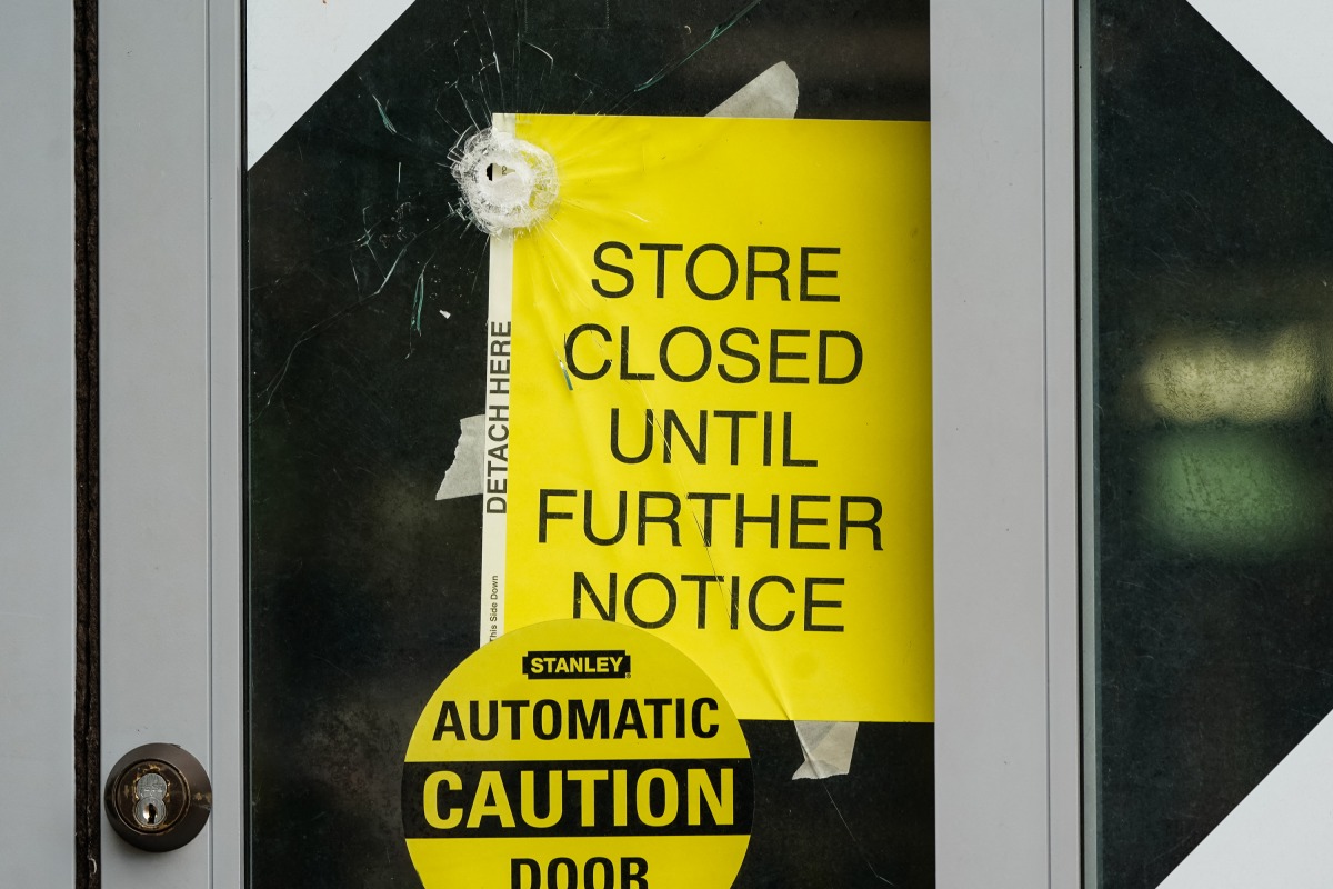 A bullet hole is seen in the door of a CVS store following a shooting that left two dead, on August 9, 2025 in Atlanta, Georgia. Photo by Elijah Nouvelage / GETTY IMAGES NORTH AMERICA / Getty Images via AFP