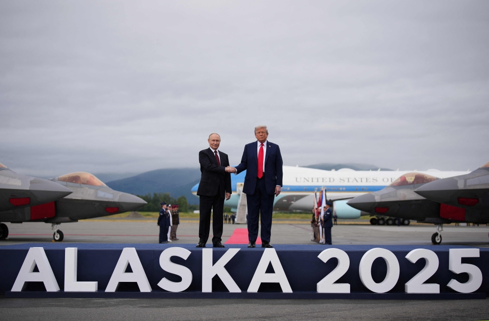 US President Donald Trump greets Russian President Vladimir Putin as he arrives at Joint Base Elmendorf-Richardson on August 15, 2025 in Anchorage, Alaska. (Photo by Andrew Harnik / Getty Images via AFP)