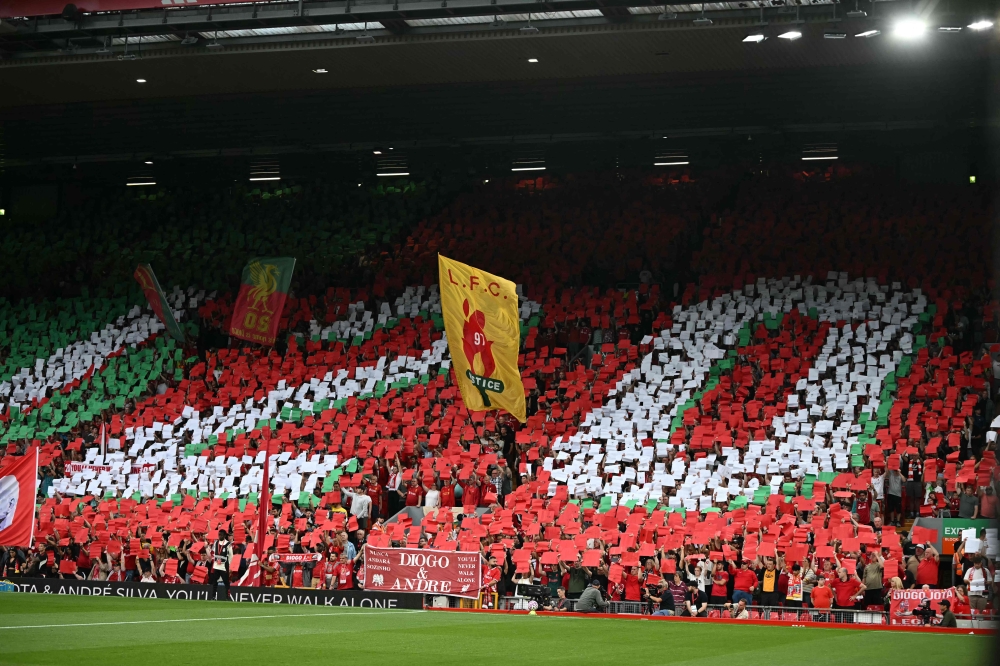 Liverpool's fans hold up cards to create a mosaic as they pay tribute to Liverpool's late Portuguese forward Diogo Jota who passed away in a car crash ahead of the English Premier League football match between Liverpool and Bournemouth at Anfield in Liverpool, north west England on August 15, 2025. (Photo by Paul Ellis / AFP)
