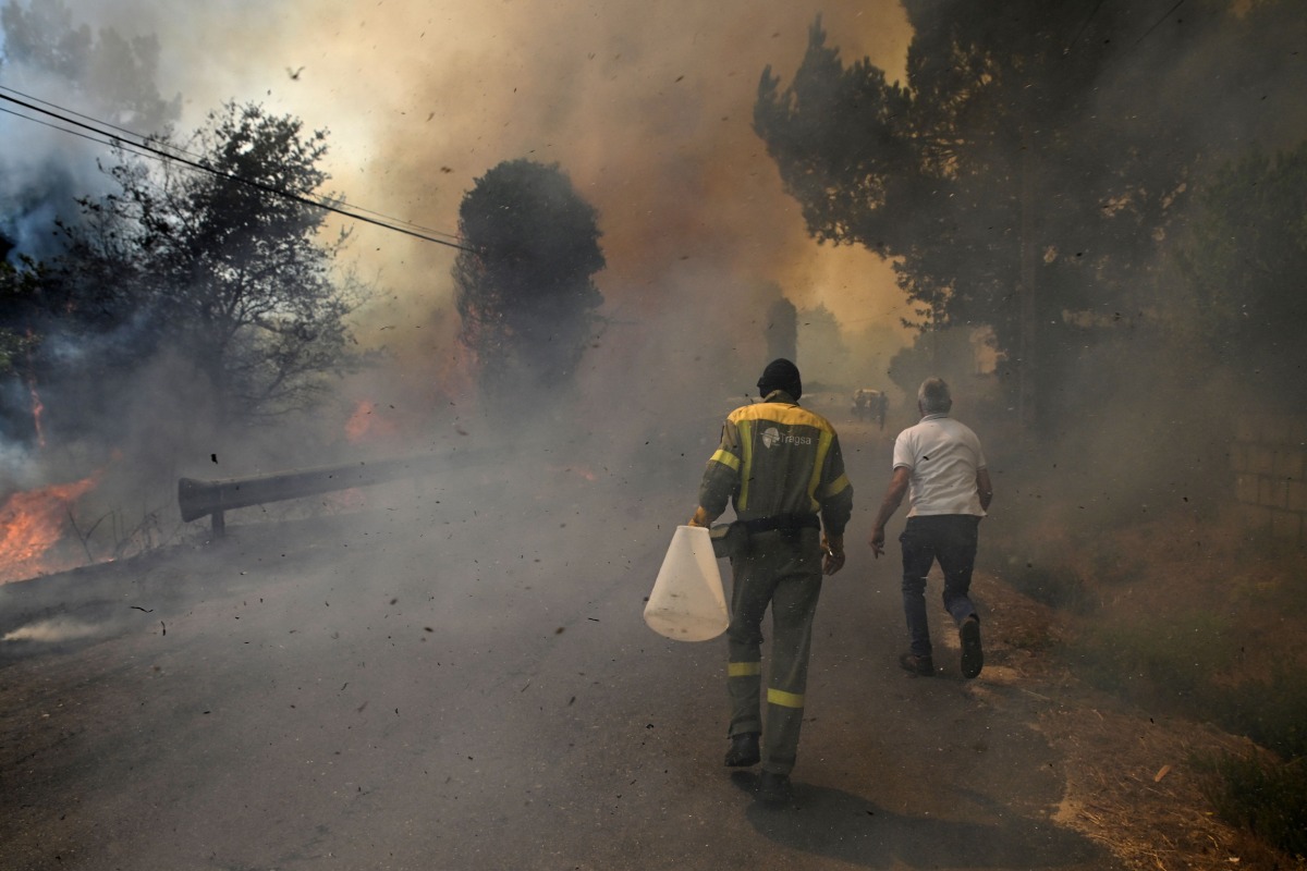 People fight a wildfire in the village of Vilarino, in Carballeda de Avia municipality, northwestern Spain, on August 17, 2025. Photo by MIGUEL RIOPA / AFP