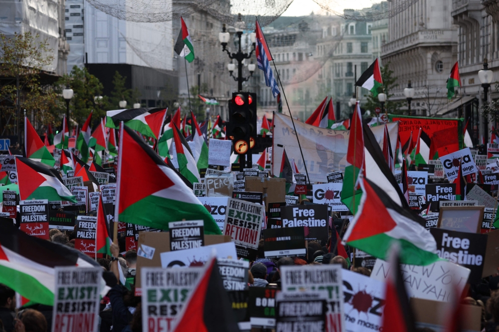 File: People holding placards and flags of Palestine take part in a 'March For Palestine', part of a pro-Palestinian national demonstration, in London on October 14, 2023. (Photo by Adrian Dennis / AFP)

