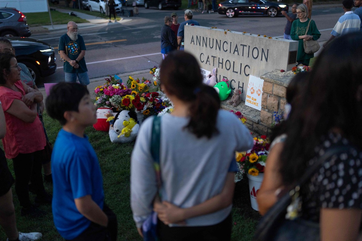 People gather at a memorial for victims of yesterday's shooting in front of Annunciation Catholic Church on August 28, 2025 in Minneapolis, Minnesota. Photo by SCOTT OLSON / GETTY IMAGES NORTH AMERICA / Getty Images via AFP