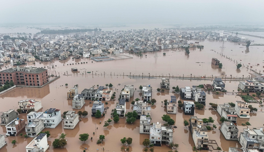 This aerial view shows partially submerged residential buildings following the overflowing of the Ravi River in Lahore on August 30, 2025. (Photo by Aamir Qureshi / AFP)