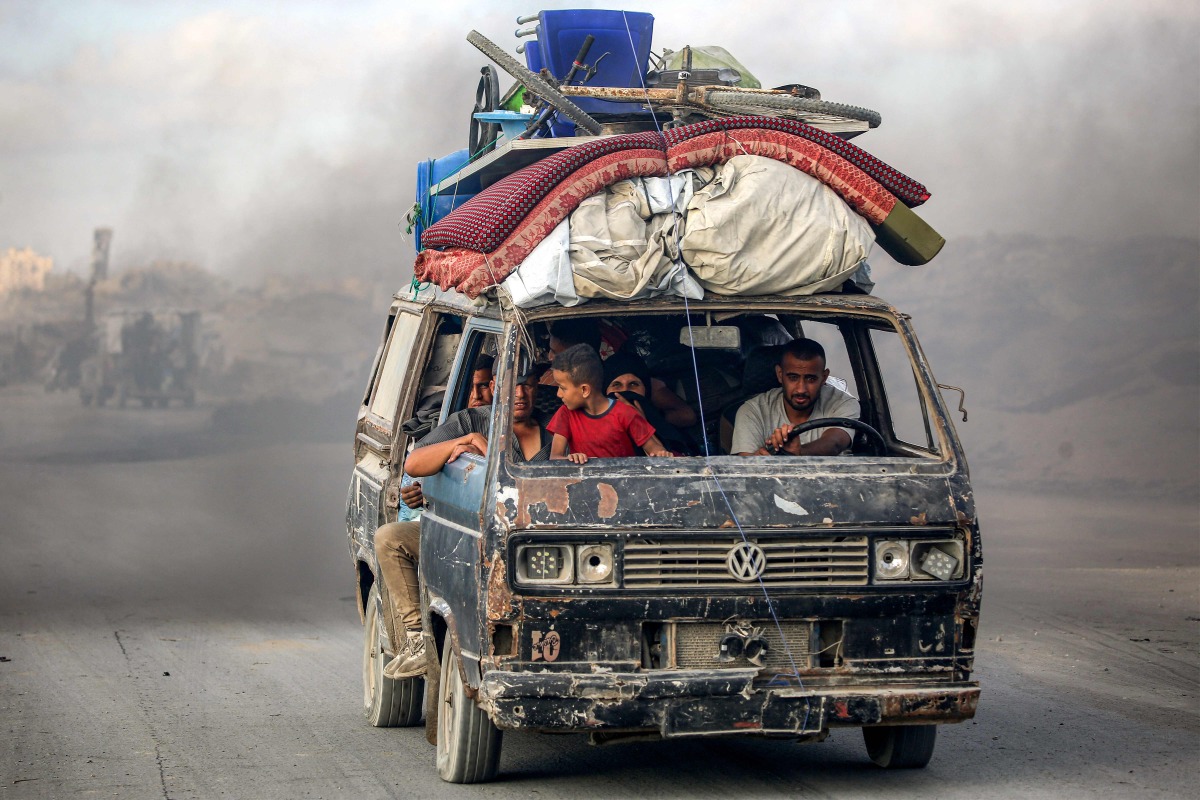 People ride a microbus carrying their belongings as they evacuate southbound from Gaza City on September 2, 2025. Photo by Eyad BABA / AFP