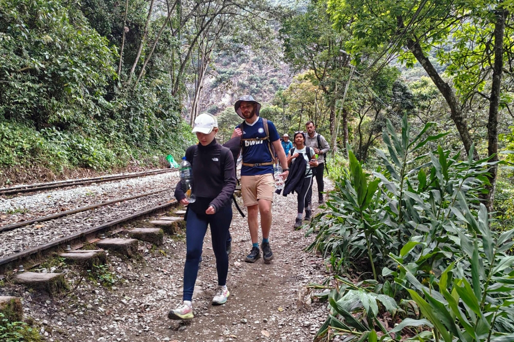 A group of tourists leaves on foot due to a protest by residents in Machu Picchu Pueblo, Peru, on September 16, 2025. (Photo by Carolina Paucar / AFP)